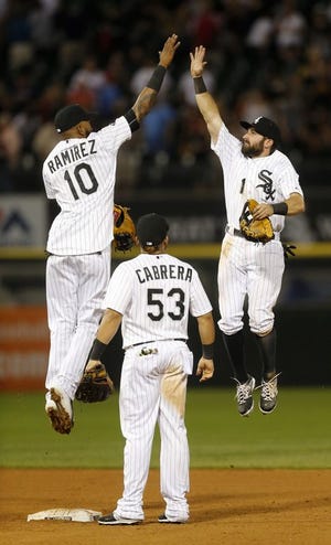 Chicago White Sox shortstop Alexei Ramirez (10) and center fielder Adam Eaton (1) celebrate the White Sox's 8-2 win over the Los Angeles Angels as Melky Cabrera watches after a baseball game Monday, Aug. 10, 2015, in Chicago.
