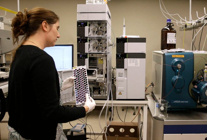 In this Aug. 10, 2015, photo, Christine Jelinek, a postdoctoral fellow at Johns Hopkins University, prepares to load a tray of vials containing cerebral spinal fluid into a liquid chromatograph in Baltimore. Dr. Akhilesh Pandey, a researcher at Johns Hopkins University, said his research analyzes both adult and fetal tissue, and by identifying which proteins are present, he can get clues that could be used to help detect cancer in adults earlier. (AP Photo/Patrick Semansky)