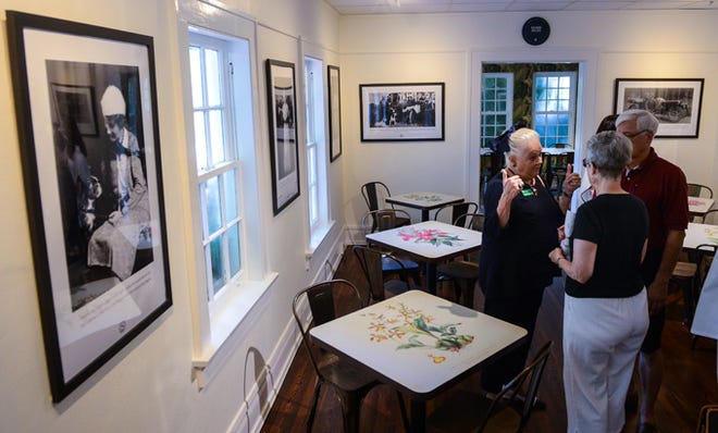 Visitors to Marie Selby Botanical Gardens view a new permanent exhibition about the life and times of Marie Selby on Tuesday. The exhibit includes rare vintage photography with historical captions and antique botanical illustrations on cafe table tops.