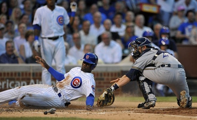 Chicago Cubs' Jorge Soler, left, slides safely into home plate on a Dan Haren single as Milwaukee Brewers catcher Jonathan Lucroy tries to apply the tag during the second inning of a baseball game, Tuesday, Aug. 11, 2015, in Chicago. (AP Photo/Paul Beaty)