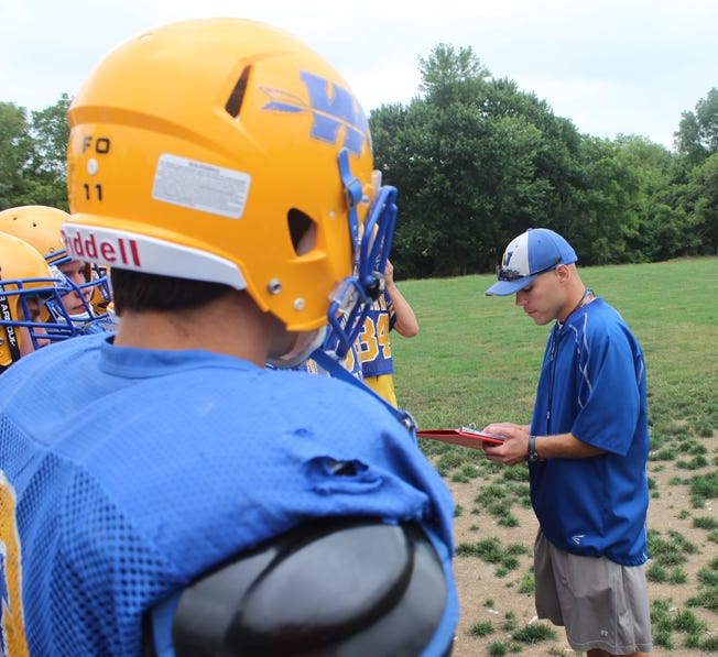 Waynesboro Indians head coach Steve Myers, right, calls out the names of players attending Monday's first day of heat acclimation practices at the Waynesboro Area Senior High School practice field.