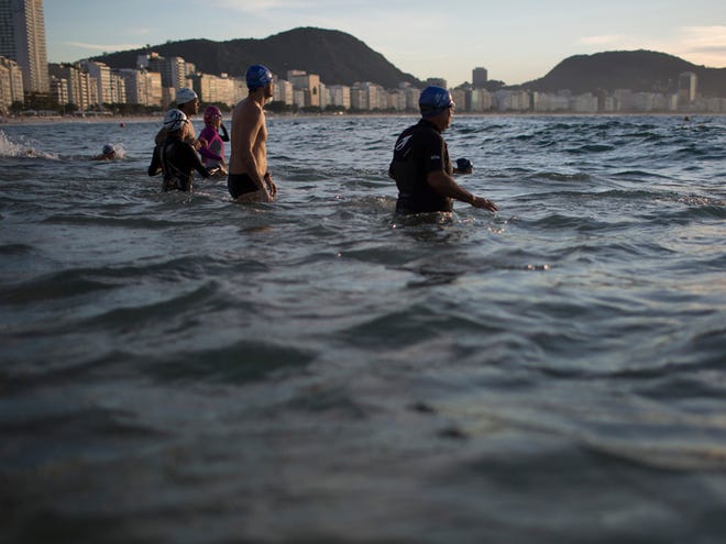 In this July 14, 2015 photo, beachgoers wade into the waters of Copacabana Beach in Rio de Janeiro, Brazil. An Associated Press analysis of water quality found not one water venue safe for swimming or boating in Rio's waters. Over 10,000 athletes from 205 countries are expected to compete in next year's Summer Olympics. Hundreds of them will be sailing in the waters near Marina da Gloria in Guanabara Bay; swimming off Copacabana Beach; and canoeing and rowing on the brackish waters of the Rodrigo de Freitas Lake.