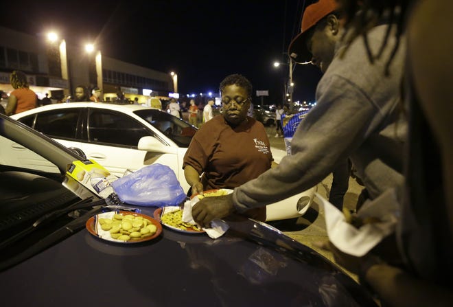 Cat Daniels puts out snacks as smaller group of protesters gather along West Florissant Avenue in Ferguson, Mo., Tuesday. The Associated Press