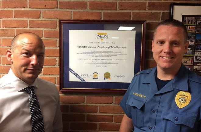 Burlington Township Public Safety Director Bruce Painter (left) and Lt. Jim Sullivan stand by the certificate of accreditation from the Commission on Accreditation for Law Enforcement Agencies (CALEA) that the department has received every three years since 2000.