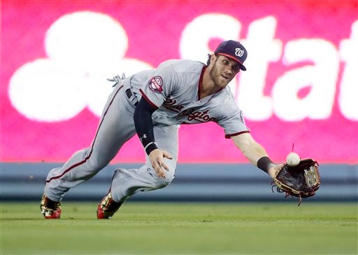 Washington Nationals right fielder Bryce Harper dives to catch a ball hit by Los Angeles Dodgers' Enrique Hernandez during the eighth inning of a baseball game, Monday, Aug. 10, 2015, in Los Angeles. (AP Photo/Danny Moloshok)