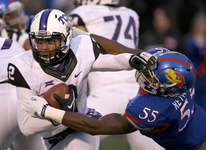 TCU quarterback Trevone Boykin (2) avoids a tackle by Kansas linebacker Michael Reynolds (55) during their game in Lawrence, Kansas, on Nov. 15, 2014. TCU coach Gary Patterson and Baylor coach Art Briles know a nearly-sure-fire way for their teams, and the Big 12 Conference, to avoid being left out of the College Football Playoff again.
