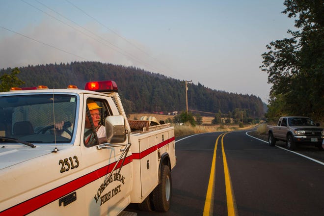 Lorane Rural Fire Protection District, a group of volunteers, works to fight the fire in Lorane on Wesneday. The crew was joined by a few other stations around the area to help get the fire under control. (Mary Jane Schulte/The Register-Guard)