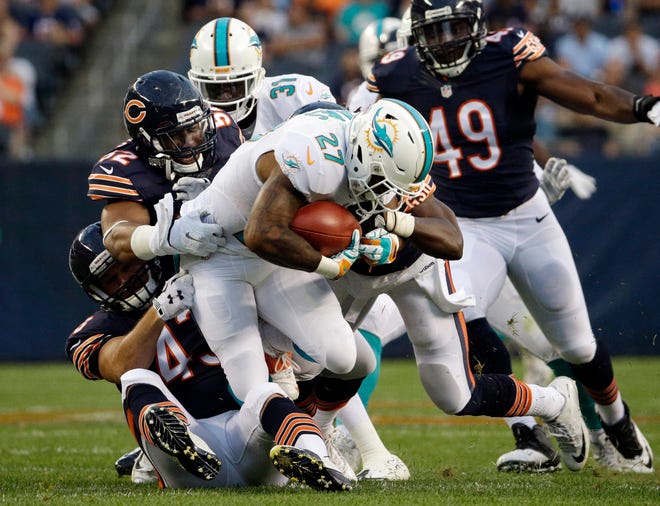 Chicago Bears outside linebacker Jon Bostic (52) tackles Miami Dolphins running back LaMichael James (27) during the first half of an NFL preseason football game in Chicago, Thursday, Aug. 13, 2015. (AP Photo/Nam Y. Huh)