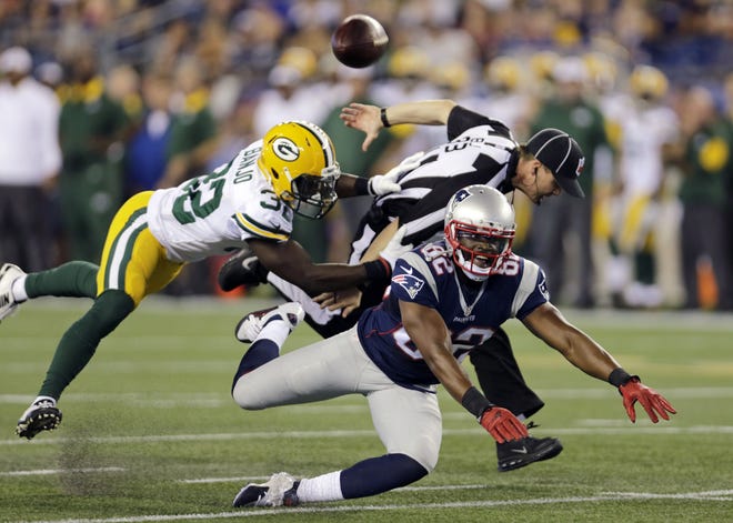 Packers strong safety Chris Banjo breaks up a pass intended for Patriots wide receiver Josh Boyce as back judge Shawn Hochuli gets tangled up in the play. THE ASSOCIATED PRESS
