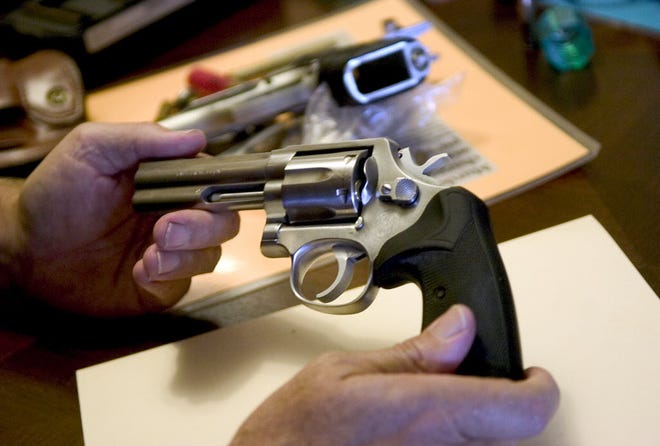 A concealed weapons permit class instructor shows the components of a revolver.
