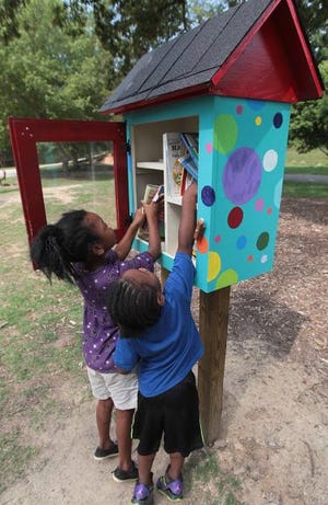 Zanya Lipscomb, 6, and T.I. McDowell, 3, check out the books inside the Little Free Library at Lineberger Park in Gastonia on Saturday morning. Ashbrook High junior Jesse Crook built the boxes and filled them with books as his Eagle Scout Service Project this year.