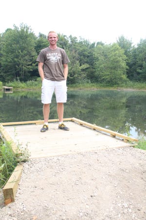 Lucas Taylor, of Zeeland, stands on a fishing dock at the Outdoor Discovery Center Macatawa Greenway that he and a team of volunteers made universally accessible for his Eagle Scout project. Justine McGuire/Sentinel staff