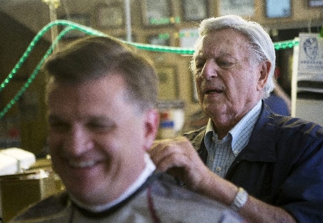 Jack Licursi, right, gets Jim Reed ready for a haircut at Licursi's Barber & Styling on July 15 in San Jose, Calif.