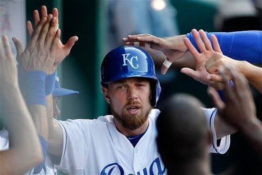 Kansas City Royals' Ben Zobrist is congratulated in the dugout after scoring on a Eric Hosmer single in the first inning of a baseball game against the Los Angeles Angels at Kauffman Stadium in Kansas City, Mo., Sunday, Aug. 16, 2015. (AP Photo/Colin E. Braley)