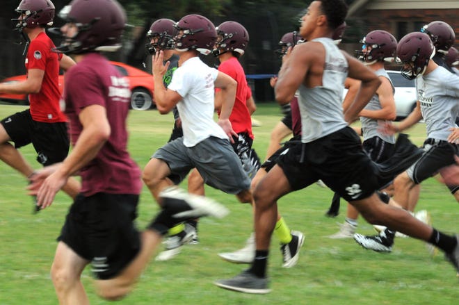Buhler High School football players sprint across the field during the first day of football practice early Monday morning, August 1, 2015.