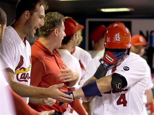 St. Louis Cardinals' Yadier Molina, right, covers his face as he is congratulated by teammate Michael Wacha after hitting a solo home run during the fourth inning of a baseball game against the San Francisco Giants Monday, Aug. 17, 2015, in St. Louis. (AP Photo/Jeff Roberson)