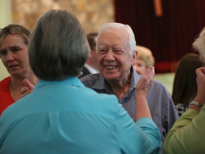 Former President Jimmy Carter reaches to embrace his brother Billy's widow, Sybil, while greeting family Sunday, following service at Maranatha Baptist Church in Plains, Ga.