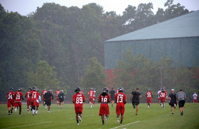 File photo - Atlanta Falcons players run toward their indoor facility during a rain storm at their NFL football minicamp Tuesday, June 18, 2013, in Flowery Branch, Ga. (AP Photo/David Tulis)