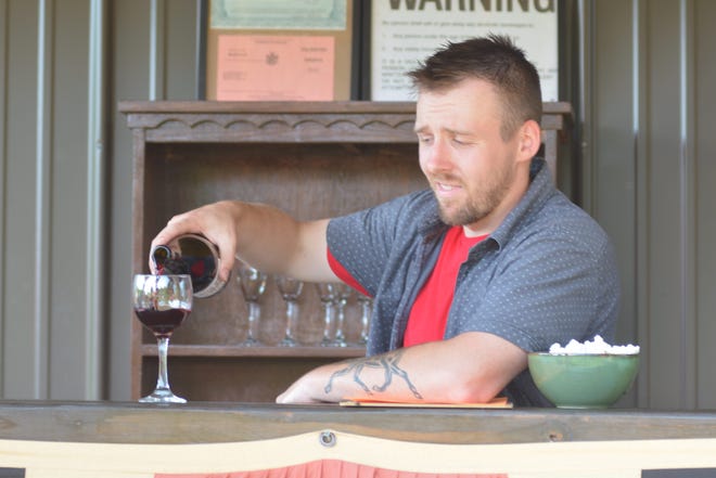 Justin Recktenwald, owner of Wild Brute Winery in Arkport pours a glass of the house wine, a 2013 Cab-Franc for a waiting customer — one of many who make Rectenwald optimistic about the future of the industry in the area. PHOTO BY JASON JORDAN