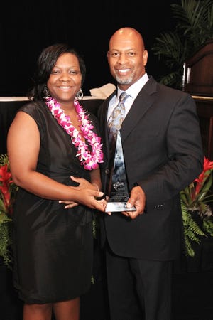 Kandi Edmonds, left, of Quality Moving Services, and Vincent Tucker, right, owner and president of the company, show off their award for MBE Class I Supplier of the Year from the Carolinas-Virginia Minority Supplier Development Council.