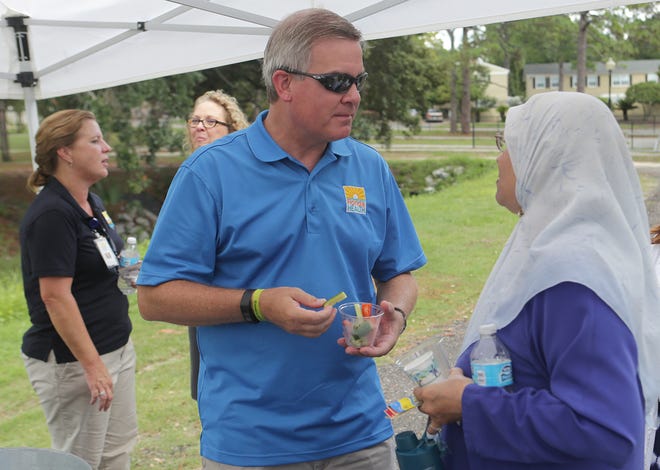 Florida Surgeon General John Armstrong samples fresh-cut vegetables provided by Bay County's Diabetes Services Program at Bay Memorial Park on Wednesday, Aug. 19, in Panama City.