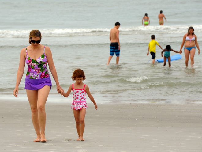 Marina Mishchemko and her daughter Elizabeth, 4, walk out of the surf in front of the Hampton Inn at 14th Ave. North in Jacksonville Beach here vacationing from California.