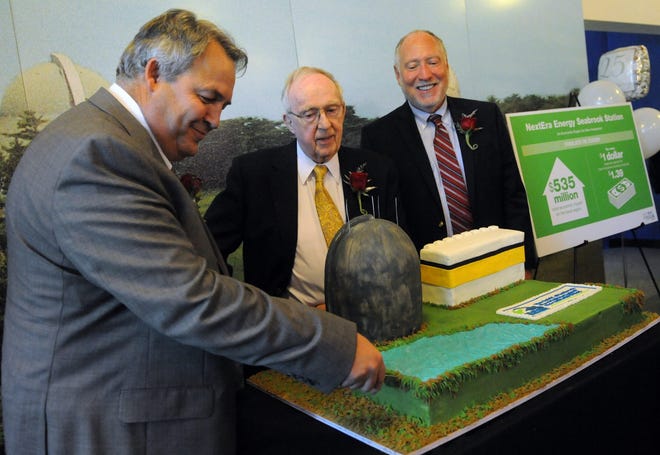 Dean Curtland, site vice president of Seabrook Station, cuts a cake depicting the plant as Ed Brown, retired president and chief executive officer of New Hampshire Yankee, center, and Ted Feigenbaum, retired vice president of plant operator of New Hampshire Yankee watch during the nuclear plant's 25th anniversary celebration on Wednesday.

Photo by Deb Cram/Seacoastonline
