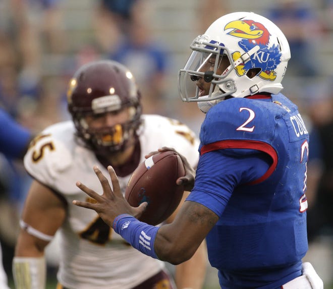 Kansas quarterback Montell Cozart (2) looks for a receiver while under pressure from Central Michigan defensive end Joe Ostman (45) during the first half of an NCAA college football game Saturday, Sept. 20, 2014, in Lawrence, Kan. (AP Photo/Charlie Riedel)