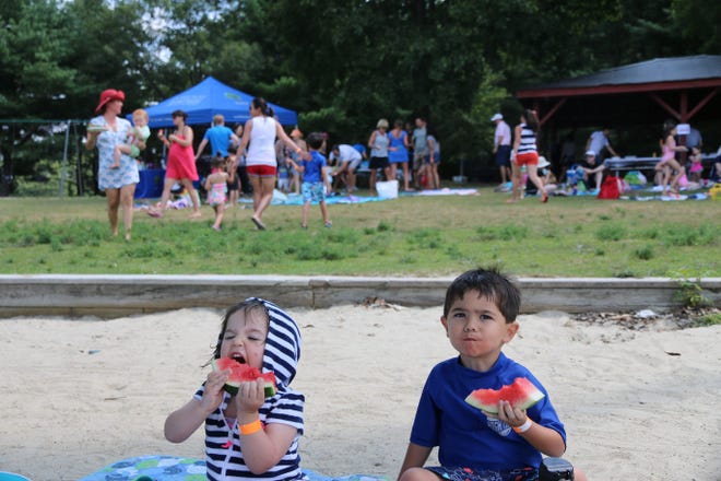 Kate and Jack Earley enjoying some watermelon at the Wellesley Mothers Forum annual cookout at Morses Pond. Courtesy photo