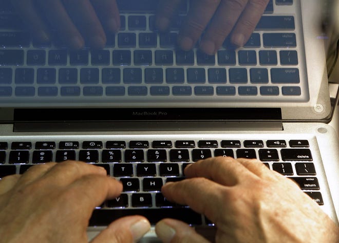 In this file photo illustration, hands type on a computer keyboard in Los Angeles. (AP Photo/Damian Dovarganes, File)