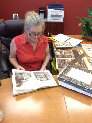 City Clerk Linda Bourgeois goes through late teacher Bessie Ethridgeís journals, photos and keepsakes found in the old Haines City library. Bourgeois will give the items to Ethridgeís great-niece at the Sept. 3 commission meeting.