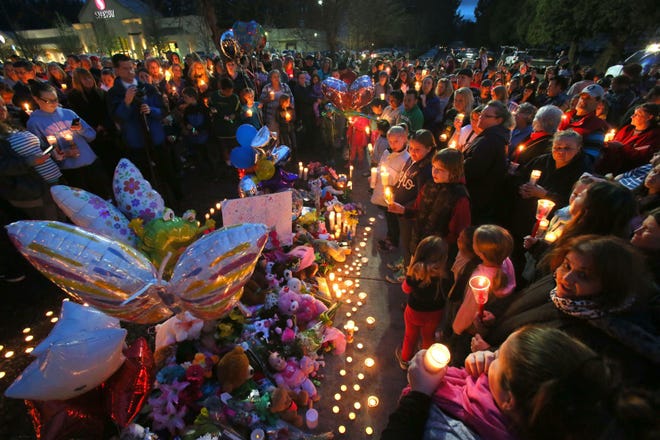 Mourners gather at a candlelight vigil Wednesday evening, February 25, 2015 at the site where three children were struck and killed in a crosswalk at 54th and Main Streets in Springfield Sunday. John Alexander Day, 8, McKenzie Mae Hudson, 5, and Tyler James Hudson, 4, were killed when Larry James La Thorpe, 68, drove through the intersection just before 5 p.m. Sunday, police said. The children’s mother, Cortney Jean Hudson, 26, was also hit. She was listed in critical condition at Sacred Heart Medical Center at RiverBend. According to the investigating officer, La Thorpe allegedly ran a red light when he struck the family.
(Brian Davies/The Register-Guard)