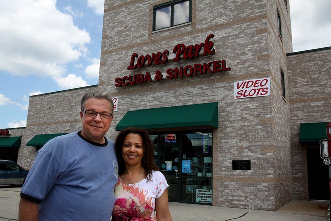 Danny Johnson and his wife, Remi, stand in front of their business, Loves Park Scuba & Snorkel. The business has a pool on-site for scuba diving lessons. JANE LETHLEAN/RRSTAR.COM