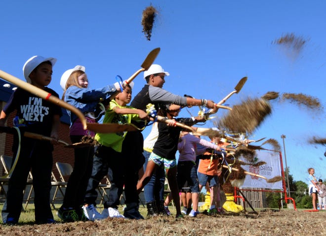 Schilling Elementary School students toss shovels of dirt Thursday morning while participating in a groundbreaking ceremony at the school.
