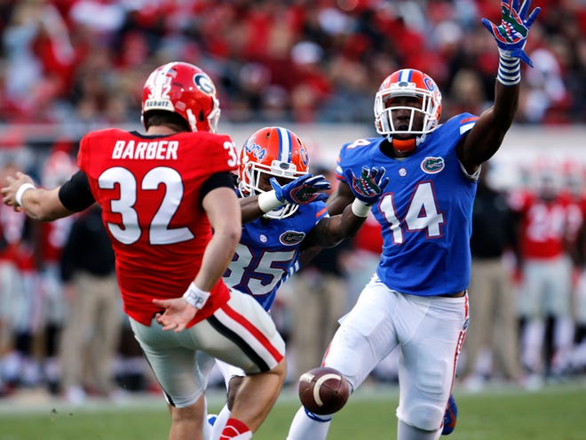 In this Nov. 1, 2014 file photo, Florida Gators wide receiver Chris Thompson and Florida Gators defensive lineman Alex McCalister (14) try for the punt block on Georgia Bulldogs punter Collin Barber (32) during the second half at EverBank Field in Jacksonville.