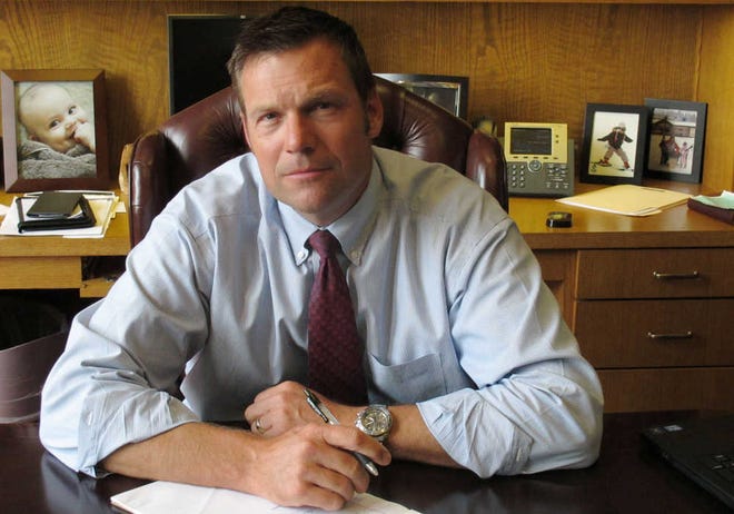 In this Aug. 1, 2013, file photo is Kansas Secretary of State Kris Kobach in his Topeka office. Secretary of State Kris Kobach said Friday one of his top deputies fired a state employee for falling short of workplace expectations rather than by failing to attend church services.