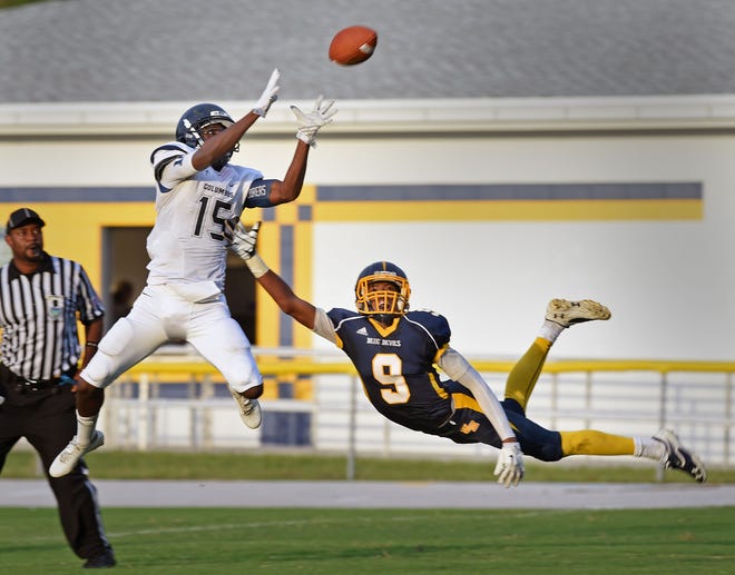 Miami Columbus' Jerrod Rollins (15) comes down with the first of two first-half touchdown catches in front of Winter Haven´s Ohaji Hawkins (9) during their game at Denison Stadium in Winter Haven on Friday.