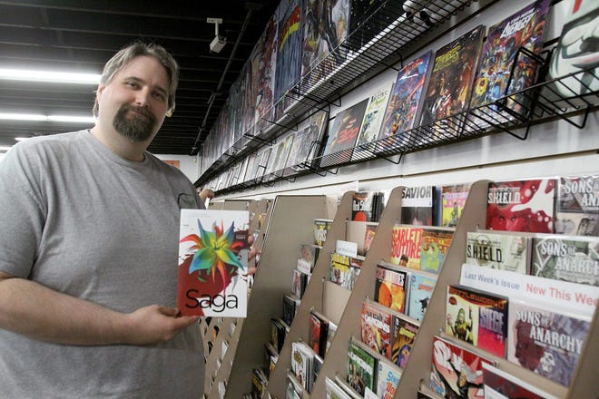 Mike Lamps, manager of Top Cut Comics in Loves Park, with a popular comic book for sale at the business. JANE LETHLEAN/RRSTAR.COM