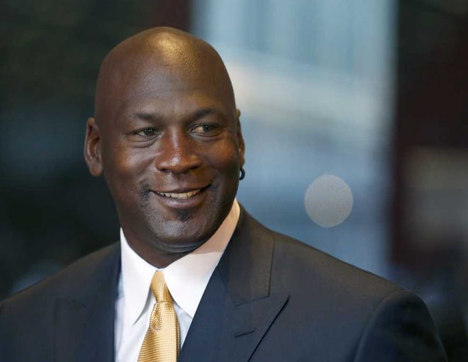 Michael Jordan smiles at reporters after a jury ordered a defunct grocery store chain to pay him $8.9 million for using his name without permission on Friday in Chicago. Jurors had to calculate how much the now-defunct grocery chain Dominick's Finer Foods should pay Jordan. They sent one note to the judge, saying: "We need a calculator." (AP Photo/Charles Rex Arbogast)