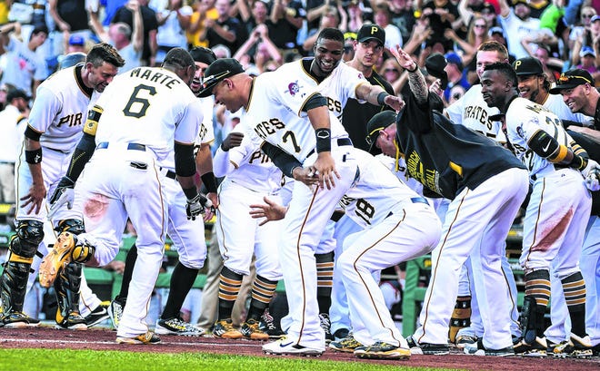 Pittsburgh Pirates' Starling Marte (6) is greeted by his teammates after hitting a bottom-of-the-ninth baseball game-winning home run off of San Francisco Giants' pitcher George Kontos Saturday, Aug. 22, 2015, in Pittsburgh. (AP Photo/Fred Vuich)