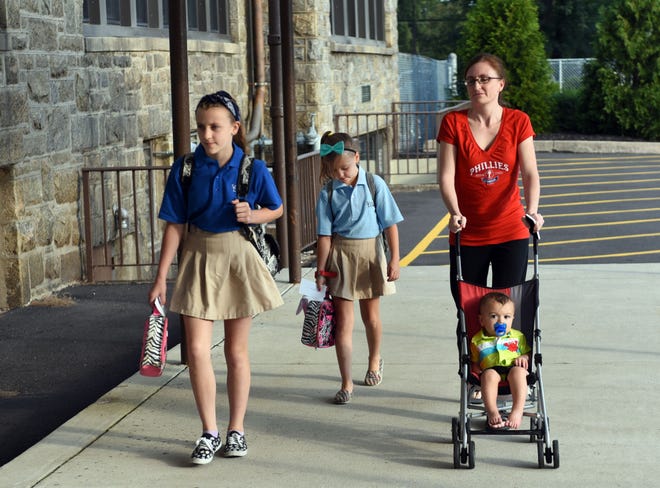 Students arriving for the start of the new school year at School Lane Charter School, Bensalem. This is the first public school in Lower Bucks County to open for the new school year. Aimee Nekoranik of Bensalem walks her two children students, Madison (6th grade) and Gracie (3rd grade) and her one year old son, Noah into school on first day. Photo by William Johnson