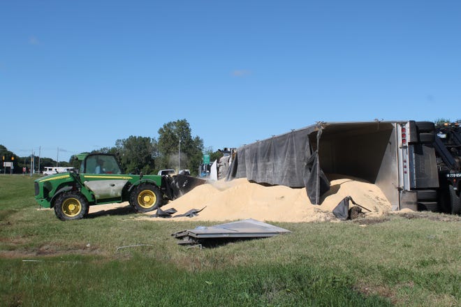A tractor scoops soybean meal from an overturned semi Monday, Aug. 24, 2015. Curtis Wildfong/Sentinel staff