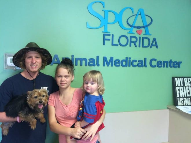 Skyler Palmer, left, Elexis Santos and their son, T.J., pose for a photo after picking up their dog, Baby, from SPCA Florida Monday afternoon. As a part of SPCA Florida and the Lakeland Fire Department's partnership, Baby was treated for smoke inhalation after a house fire Thursday, Aug. 20.