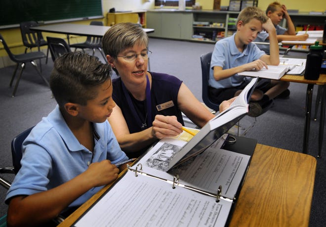 Laura Von Bergen, fourth-, fifth- and sixth-grade teacher, helps Deacon McDonald, 9, during class at Cornerstone Classical School in Salina.