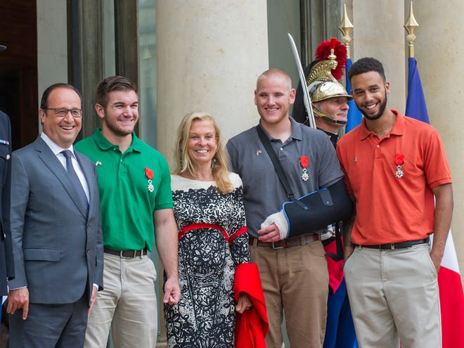 From left : French President, Francois Hollande, U.S. National Guardsman from Roseburg, Oregon, Alek Skarlatos, U.S. Ambassador to France Jane D. Hartley, U.S. Airman Spencer Stone and Anthony Sadler, a senior at Sacramento University in California, pose for photographers as they leave the Elysee Palace in Paris, France, Monday.