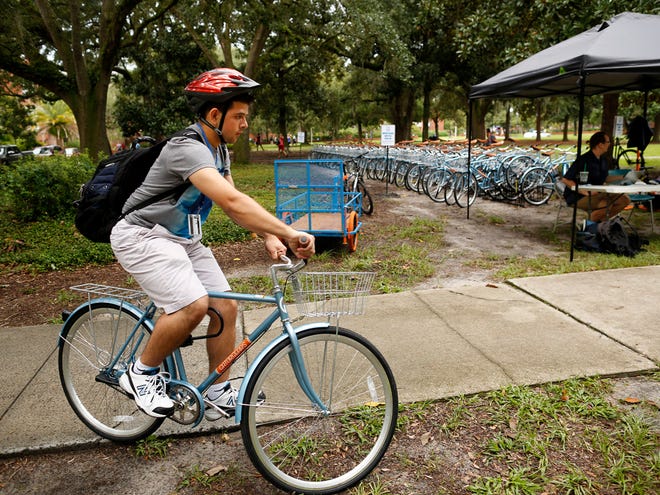 University of Florida freshman Eric Los Kamp, 17, picks up his Gator Gears bicycle at the Plaza of the Americas on the UF campus Monday.