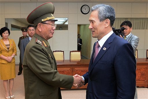 In this photo provided by the South Korean Unification Ministry, South Korean presidential security adviser Kim Kwan-jin, right, shakes hands with Hwang Pyong So, North Korea's top political officer for the Korean People's Army, after their meeting at the border village of Panmunjom in Paju, South Korea, Tuesday, Aug. 25, 2015. After 40-plus-hours of talks, North and South Korea on Tuesday pulled back from the brink with an accord that allows both sides to save face and, for the moment, avert the bloodshed they've been threatening each other with for weeks. (The South Korean Unification Ministry via AP)