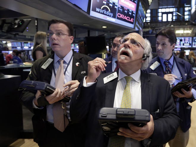 Peter Tuchman, foreground right, works with fellow traders on the floor of the New York Stock Exchange, Monday, Aug. 24, 2015. U.S. stock markets plunged in early trading Monday following a big drop in Chinese stocks.