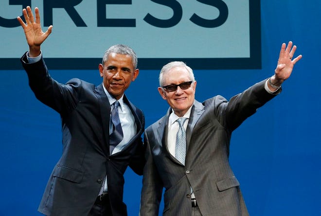 President Barack Obama, left, and Senate Minority Leader Sen. Harry Reid wave onstage at the National Clean Energy Summit, Monday, Aug. 24, 2015, in Las Vegas. The president used the speech to announce a set of executive actions and other efforts aimed at making it easier for homeowners and businesses to invest in green energy improvements. (AP Photo/John Locher)