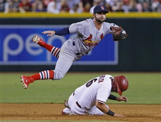 St. Louis Cardinals second baseman Greg Garcia, top, forces out Arizona Diamondbacks' David Peralta (6) as he turns a double play in the sixth inning of a baseball game Monday, Aug. 24, 2015, in Phoenix.